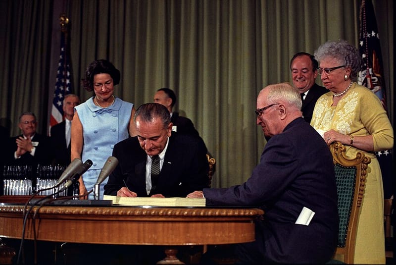 President Lyndon Johnson signing the Medicare bill with Harry Truman beside him