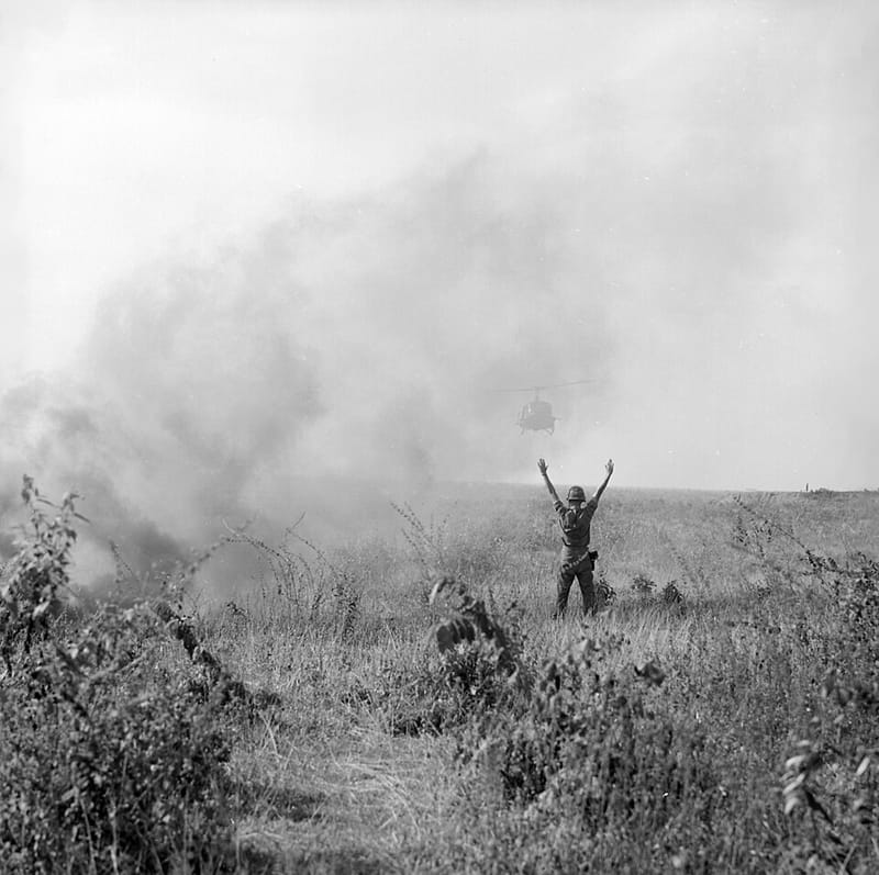 A U.S. soldier guiding a UH-1 helicopter in to land in Vietnam