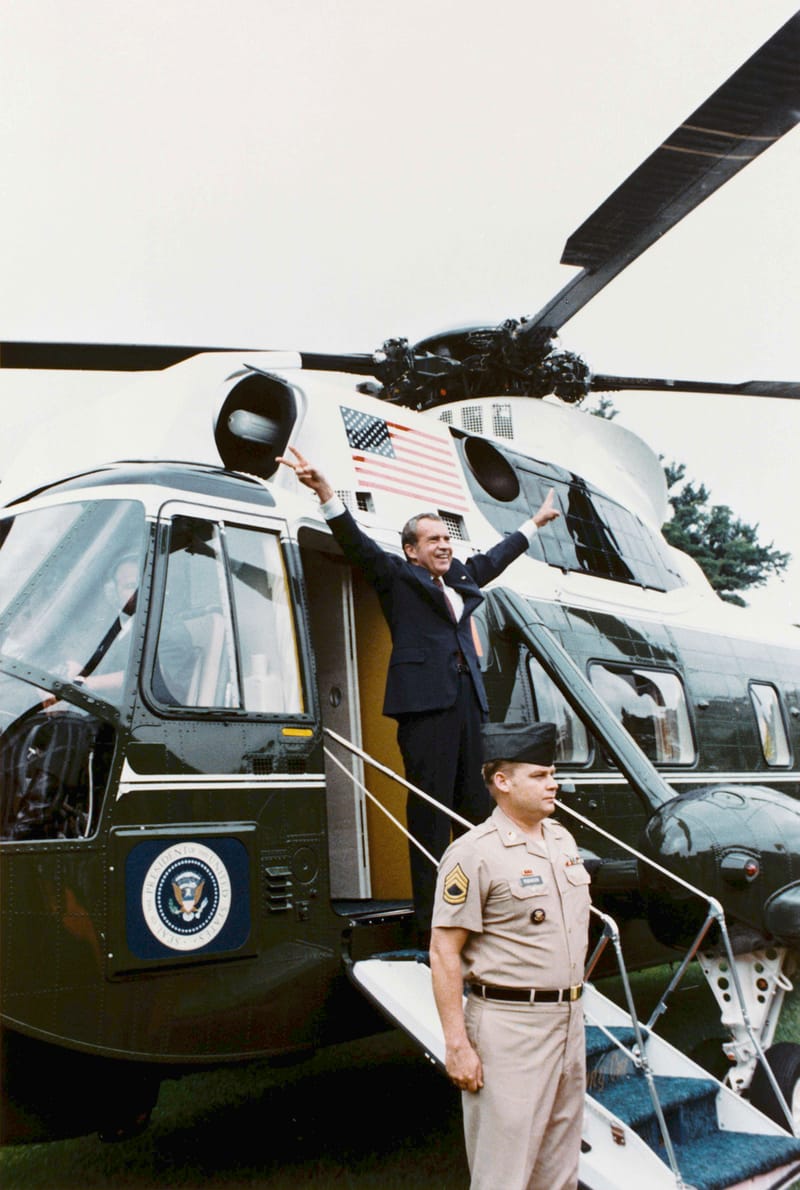 Richard Nixon waving from the steps of a helicopter as he leaves the White House after resigning