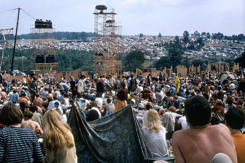 Festival-goers with a blanket tent in the crowd at Woodstock, 1969